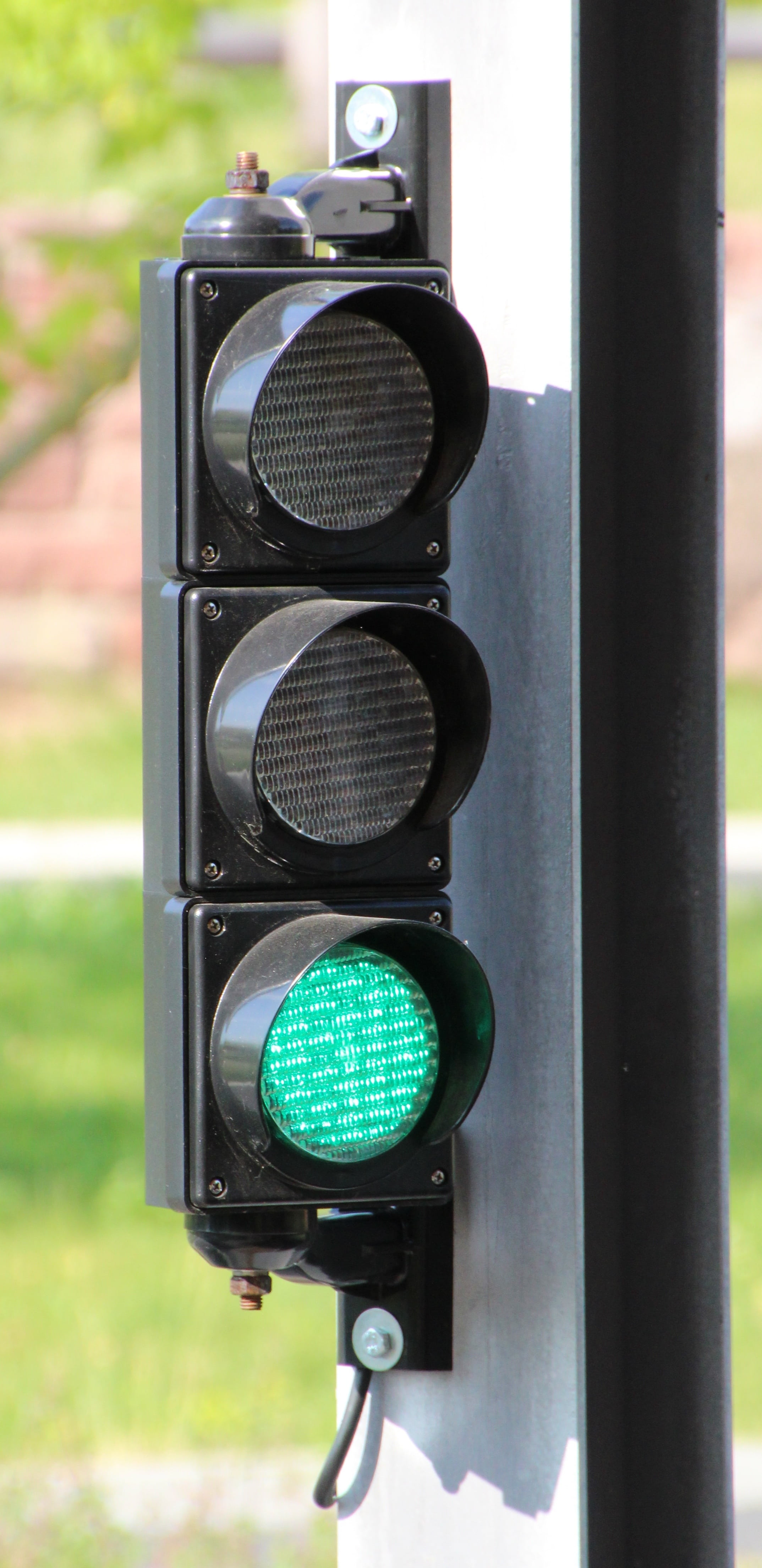 Vertical stop light with green illuminated at the bottom